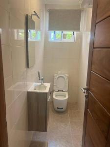 een kleine badkamer met een toilet en een wastafel bij Cozy Airport Penthouse,Accra in Accra