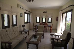 ein Wohnzimmer mit einem Sofa und einem Tisch in der Unterkunft Eve Pissouri Rozaki Villa in Pissouri