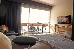 a living room with a bed and a table and chairs at Layoo, Tu casa en Oaxaca 102 in Oaxaca City
