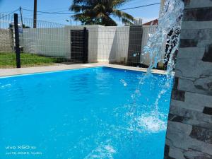 a swimming pool with a water fountain at Santai D villa bumiputra shja in Merlimau