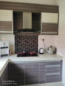 a kitchen with a stove with pots and pans on it at Santai D villa in Merlimau