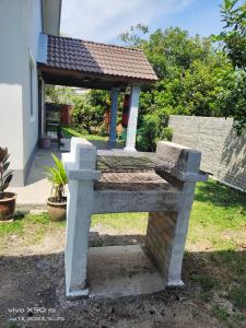 a stone bench with a gazebo in a yard at Santai D villa in Merlimau