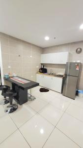 a kitchen with a table and a refrigerator at Lost World Of Tambun Coco Guest House in Ipoh