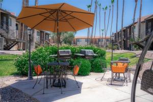 une terrasse avec un parasol, des tables et des chaises dans l'établissement 232 Fully Furnished 1BR Suite-Prime Location, à Scottsdale