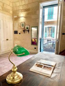 a table with a green lamp and a book on it at Vohis Luxury House - Fast Wi-fi & Easy parking in Lecce