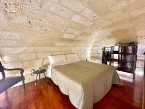 um quarto com uma cama numa parede de pedra em Vohis Luxury House - Fast Wi-fi & Easy parking em Lecce