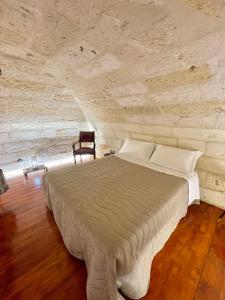 uma cama num quarto com uma parede de pedra em Vohis Luxury House - Fast Wi-fi & Easy parking em Lecce