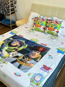 a bed with a toy story blanket on it at Lost World Of Tambun Coco Guest House in Ipoh