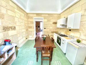 uma cozinha com uma mesa de madeira e electrodomésticos brancos em Vohis Luxury House - Fast Wi-fi & Easy parking em Lecce