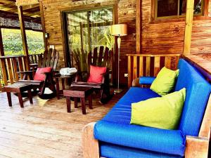 a living room with a blue couch and chairs at Ocean Melody in Uvita