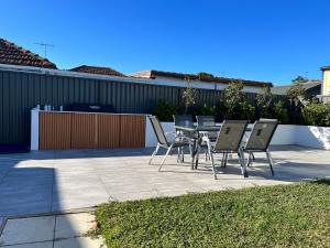 um pátio com cadeiras, uma mesa e uma cerca em The South bay's home-Big RoomA em Sydney