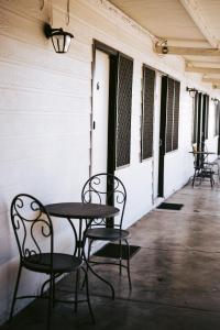 einen Tisch und Stühle auf der Veranda eines Gebäudes in der Unterkunft Rix Hotel Motel in Charters Towers