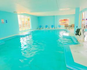 einen großen Pool mit blauen Wänden und Fenstern in der Unterkunft Ocean Resort in Virginia Beach