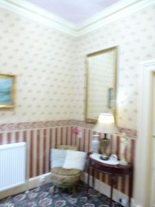 a living room with a lamp and a chair at Macdonald House in Inverness