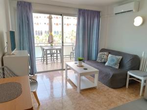 ein Wohnzimmer mit einer Couch und einem Tisch in der Unterkunft in the heart of Playa del Inglés in San Bartolomé de Tirajana