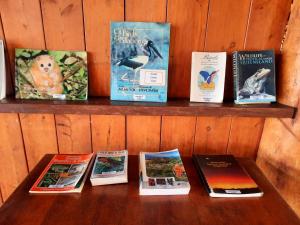 a wooden shelf with books on it at Wild Nature Lodge, Mareeba Wetlands in Biboohra