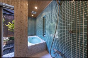Machiya Oozora في كيوتو: حمام مع حوض استحمام وجدار من البلاط