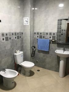 a bathroom with a toilet and two sinks at Spacious 2-rooms apartment in Martil