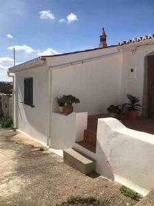 uma casa branca com escadas e uma planta nela em Casa Tranquila Barrada em Alcoutim