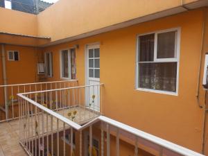 an orange house with a balcony with flowers on it at Agradable y cómodo departamento a 5 minutos del aeropuerto in Mexico City