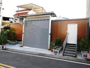 ein Gebäude mit einer Garagentür und einer Treppe daneben in der Unterkunft 雅如小築電梯民宿 in Puli