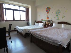 um quarto de hotel com duas camas e uma janela em 雅如小築電梯民宿 em Puli