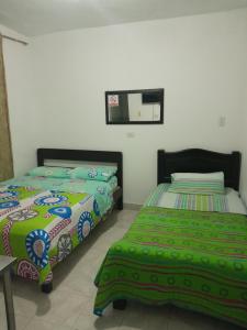 two beds sitting next to each other in a bedroom at HOTEL CASA BLANCA in Popayan