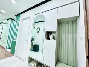een kamer met witte kasten en een spiegel bij Green Diamond Luxury Apartment 15A11 in Ha Long