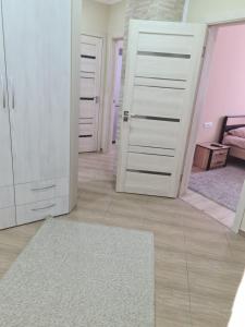 Cette chambre dispose de portes blanches et d'un tapis blanc. dans l'établissement New Аpartment Balti, à Bălţi