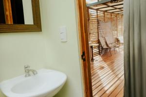 a bathroom with a sink and a view of a porch at Wanderlust in Jacó