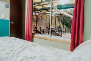 a bedroom with a bed and a window with a view of a patio at Wanderlust in Jacó
