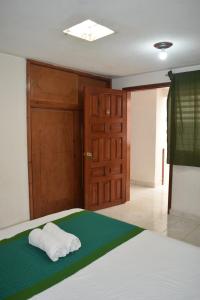 1 dormitorio con 1 cama con 2 toallas en Casa Natura en San Cristóbal de Las Casas