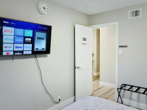 uma televisão de ecrã plano pendurada numa parede num quarto em Brand new suite, 1mi to Meta, 3mi to Stanford em East Palo Alto