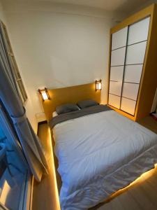a bedroom with a bed and a large window at Japanese Zen Room Citra Plaza Nagoya Batam in Nagoya