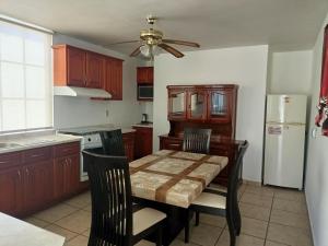 a kitchen with a table and chairs and a white refrigerator at Estancia Santa Fe in Celaya