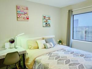 1 dormitorio con cama, escritorio y ventana en Brand new suite, 1mi to Meta, 3mi to Stanford en East Palo Alto