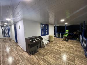 una sala de estar con piano y una habitación con balcón en Casa vacacional Campestre Filandia Quindio, en Filandia