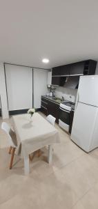a kitchen with a white table and a white refrigerator at Plaza Urbana 2 I in Mar del Plata
