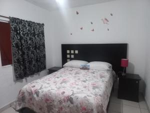 een slaapkamer met een bed met een zwart-wit dekbed bij Cómodo & confortable apartamento. 5 minutos del aeropuerto in Mexico-Stad