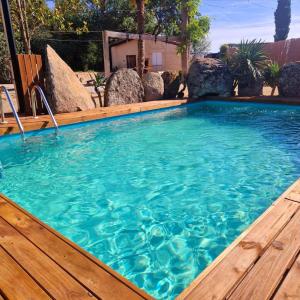 a swimming pool with a wooden deck and a large pool at Complejo Oasis Beach sobre el Rio in Huerta