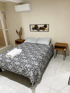 a bedroom with a bed with a black and white blanket at Casa Familiar Chocolate - Olímpica - 5 Min del Malecón in Mazatlán