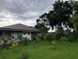 a house with a grass yard in front of it at Sheila’s Villa in Leyte