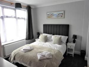 a bedroom with a bed with two towels on it at 3BD House Minutes from Great Yarmouth Seaside in Great Yarmouth