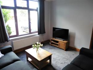 a living room with a television and a coffee table at 3BD House Minutes from Great Yarmouth Seaside in Great Yarmouth