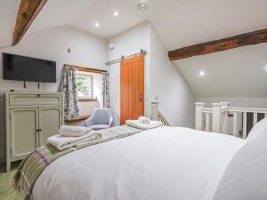a bedroom with a large white bed and a tv at Walnut Cottage - Uk43995 in Fairfield