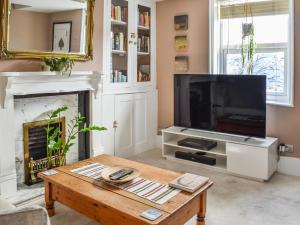 a living room with a television and a coffee table at The Epple Bay Retreat in Birchington