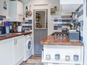 a kitchen with white cabinets and a washer and dryer at The Epple Bay Retreat in Birchington