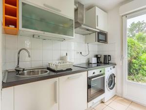 - une cuisine blanche avec un évier et un lave-vaisselle dans l'établissement Appartement Hendaye, 2 pièces, 2 personnes - FR-1-2-436, à Hendaye