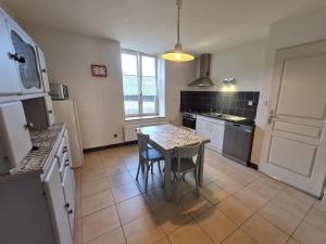 a kitchen with a table with chairs and a refrigerator at Gîte cosy face au parc des Bosquets, avec parking, terrasse et à deux pas du château de Lunéville - FR-1-584-293 in Lunéville