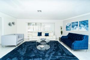 - un salon avec un canapé bleu et une table dans l'établissement Waterfront Villa Heated Pool Spa Walk To Beach, à Fort Lauderdale
